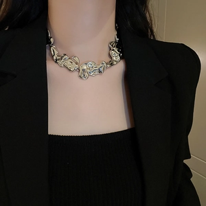 Close-up of irregular silver liquid lava style necklace on model wearing black blazer