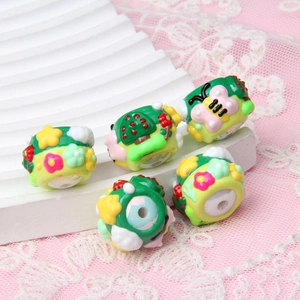 Close-up of hand-painted acrylic beads with mushroom and flower motifs for DIY crafts