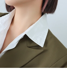 Macro detail of olive green blazer lapel with twill texture over white shirt collar