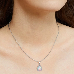 Teardrop opal pendant necklace with zircon halo on silver chain worn by a model