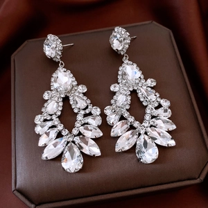 Détail de boucles d'oreilles pendantes argentées avec cristaux étincelants