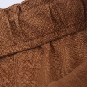 Brown midi skirt with drawstring waist showing elasticated fabric and detailed stitching