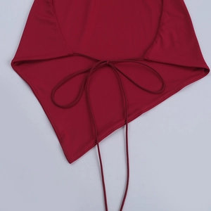 Detail of burgundy halter top featuring thin strap ties and asymmetrical hem design