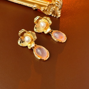 Detail of vintage flower stud earrings with white pearl and pink gemstone pendant