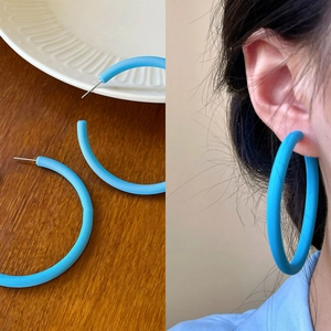 Detail view and model shot of blue matte C-shaped round hoop earrings in summer style
