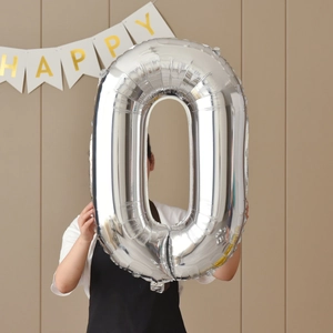 Large silver number 0 foil balloon held by a person for birthday party decor