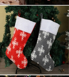 Detail of red and grey knitted Christmas stockings with snowflake patterns and plush trim