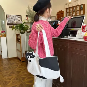Detail of cute cat-shaped white canvas tote bag with ears and tail in cafe setting