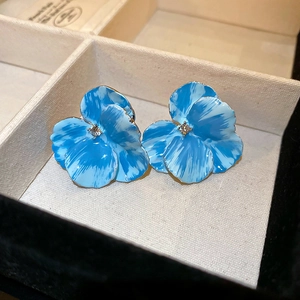 Detail view of vintage blue flower enamel stud earrings with gold trim in jewelry box