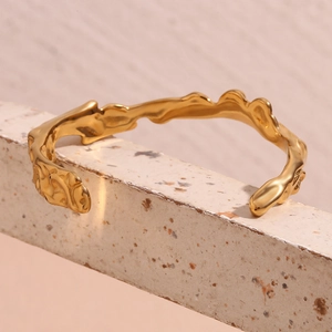 Detail of 18K gold-plated stainless steel cuff with irregular hammered wave texture