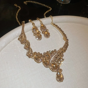 Sparkling champagne crystal waterdrop necklace and earring set on white jewelry tray