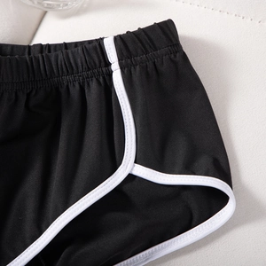 Detail des hochelastischen Bunds und verstärkter Nähte an schwarzen Sportshorts