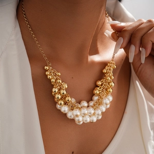 Baroque retro gold beaded necklace with white faux pearls on female model's neck
