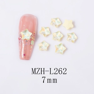 Close-up of 7mm iridescent yellow star nail art charms with faceted 3D cut details