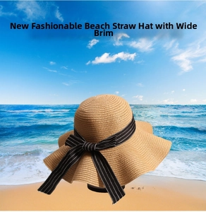 Detail of woven straw beach hat featuring a stylish black and white striped bow accent