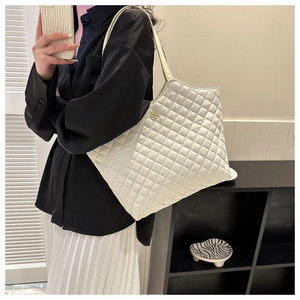 Détail d'un cabas blanc matelassé avec fermoir fleur dorée et texture en cuir