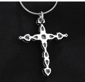 Gros plan du pendentif croix avec sertissages en zircon coeur et détails évidés