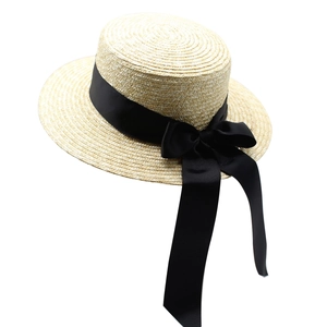 Détail d'un chapeau de paille classique avec tressage fin et ruban gros-grain noir