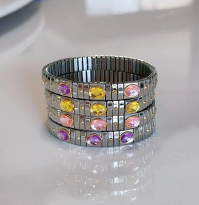 Detail of stretch stainless steel bracelet with colorful oval gemstones and silver finish