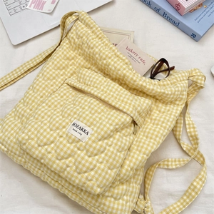 Detail of yellow heart-quilted pattern on plush backpack with branded woven label