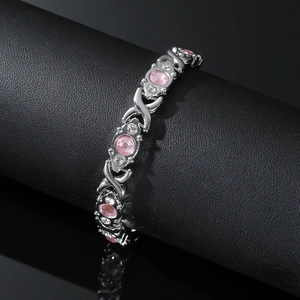 Close-up of silver magnetic bracelet with pink oval gemstones and sparkling rhinestones