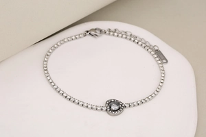 Macro detail of silver stainless steel tennis bracelet with sparkling heart zircon stone