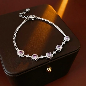 Elegant silver bracelet with five purple round zircons on a leather jewelry box
