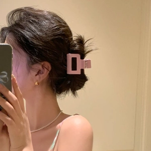 Pink matte square hair claw clip for women shown on hair in a stylish side view styling