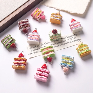 Macro display of eleven resin Napoleon cake miniature charms with secure metal rings