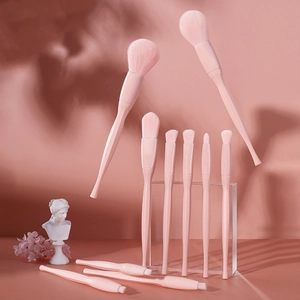 Detailed view of pink makeup brush set with soft bristles on aesthetic floral background