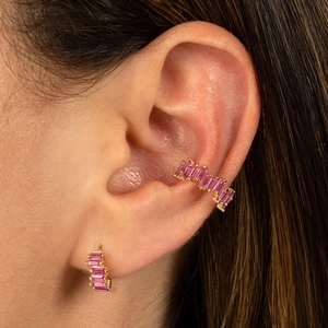 Macro shot of 18k gold ear cuff with baguette-cut pink zircon stones on ear