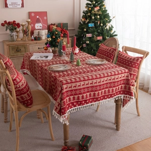 Red Christmas tablecloth with reindeer jacquard pattern and tassels in a festive setting