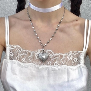 Vintage Y2K silver heart pendant necklace with intricate engraved details on a model