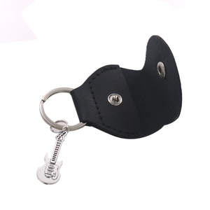 Detail view of open black leather guitar pick case with metal ring and guitar charm
