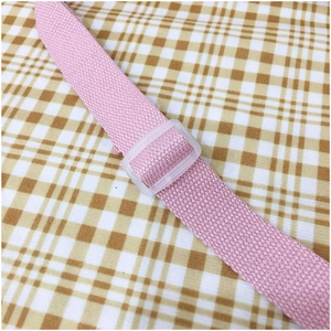 Close-up of pink woven canvas shoulder strap with transparent plastic adjustment buckle
