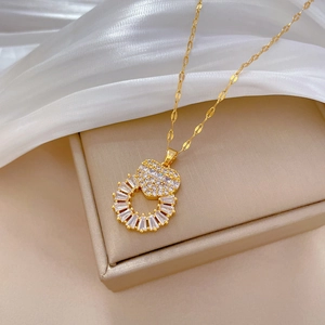 Elegant gold heart and circle necklace with sparkling crystals on a jewelry box