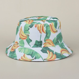 Double-sided bucket hat with white base and vibrant yellow banana and green leaf print