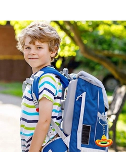 Close-up of a colorful PVC Mexican hat keychain hanging on a child's blue backpack