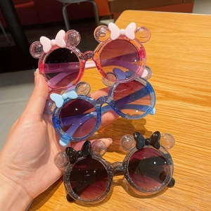 Detailed view of three glitter cartoon sunglasses with cute round ears and bows
