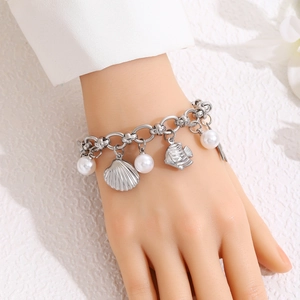 Bracelet marin argenté avec perles et breloques coquillage et poisson au poignet