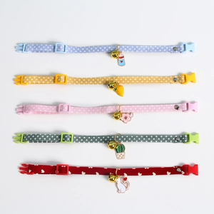 Close-up of colorful pet collars with avocado pendants and bells in various patterns