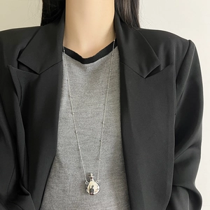 Silver perfume bottle necklace on black blazer, minimalist luxury long sweater chain