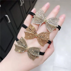 Detailed view of sparkly rhinestone butterfly hair ties in gold, silver, and bronze