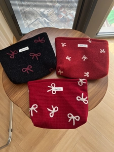Three-piece set of red and black bow embroidered cosmetic bags in various textures
