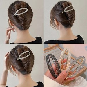 Detailed view of elegant floral hair clips with rhinestones and pearls on a French twist