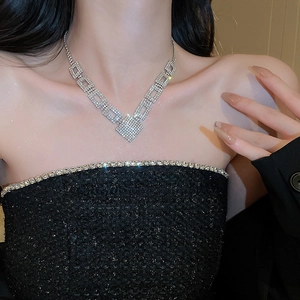 Close-up of luxury rectangular linked V-shaped necklace with crystals on a female model