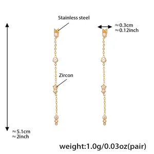 Détail de boucles d'oreilles pompons en acier doré avec zircon et dimensions