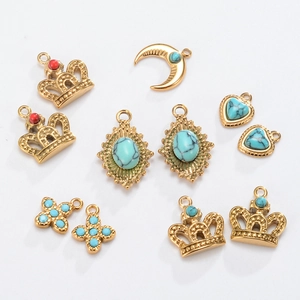 Detailed flat lay of golden crown moon and heart charms with turquoise stone inlays