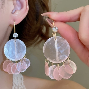 Detail of tassel earrings with white and pink shell discs and gold cubic zirconia studs