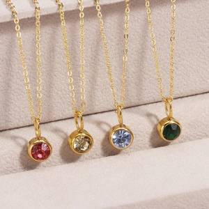 Gold birthstone necklaces with round bezel-set crystals in multiple vibrant colors